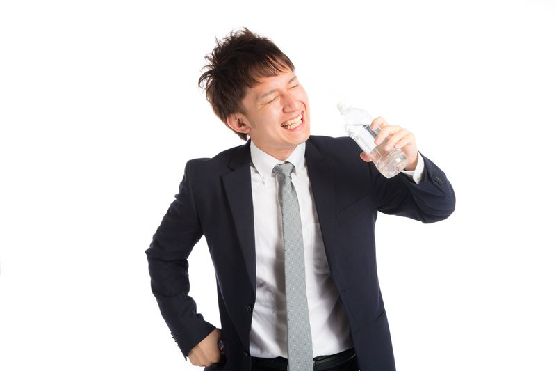 飲み物でひと息つく会社員